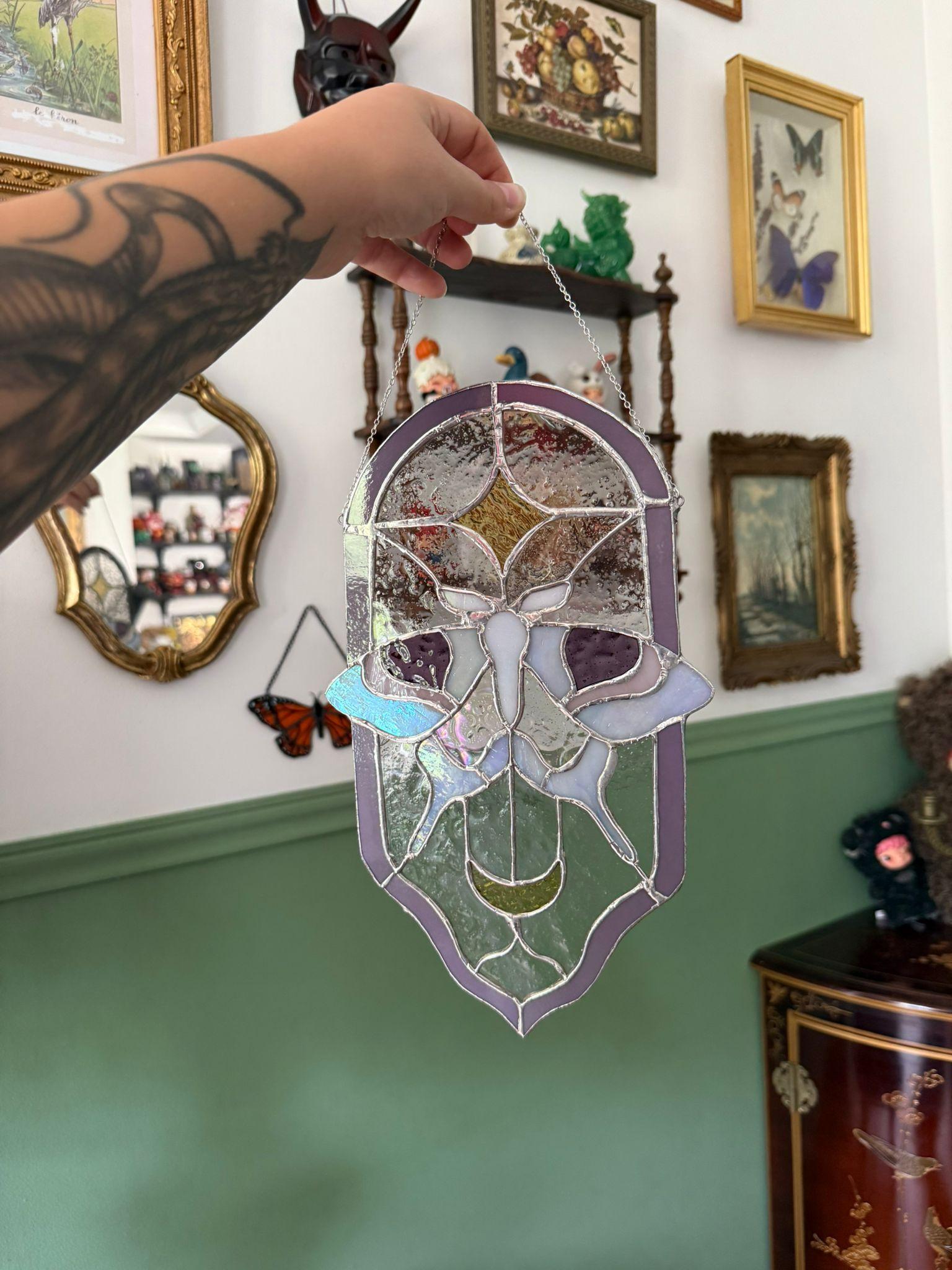 Vitrail en arche représentant une silhouette ailée aux teintes violettes